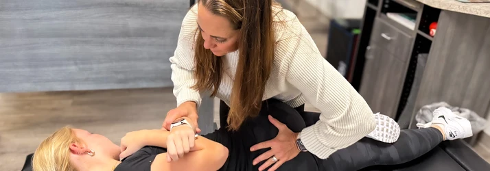 Dr. Sandy Ager performing a back adjustment on a patient in a treatment room.