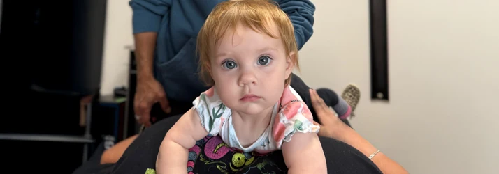 Baby Laying Prone on Mother's Stomach While Receiving Chiropractic Care